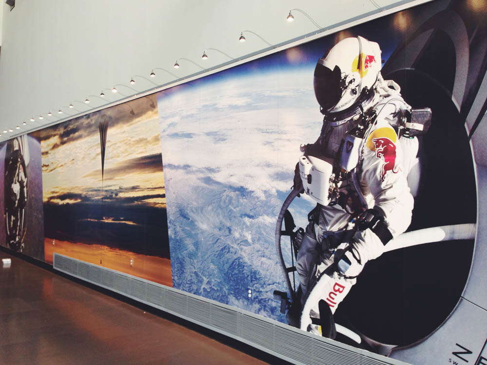 Wall mural of person flying with Red Bull suit and helmet above earth