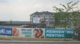 Construction site of townhomes with signs promoting rental properties. 