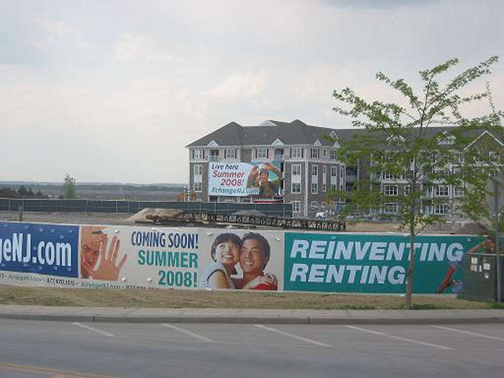 Construction site of townhomes with signs promoting rental properties. 