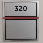 Room sign that says 320 in braile