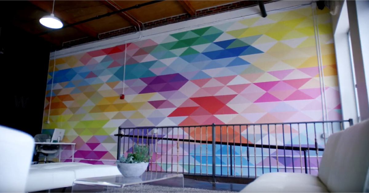 White wall with varying colored triangles.