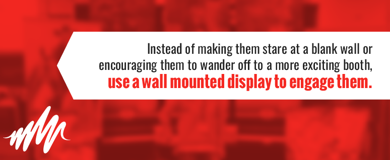 Use a wall mounted display to engage trade show attendees, instead of making them stare at a blank wall or encouraging them to wander off to a more exciting booth.